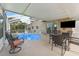 Relaxing screened pool with outdoor dining area, mounted TV, and easy access to the home's interior at 13003 Carlington Ln, Riverview, FL 33579