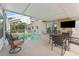 Inviting screened-in pool area features ample seating and a TV, ideal for outdoor relaxation and entertainment at 13003 Carlington Ln, Riverview, FL 33579