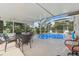 Inviting pool with screened enclosure, complemented by an outdoor dining area and lush landscaping at 13003 Carlington Ln, Riverview, FL 33579