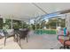 Relaxing screened-in pool area includes an outdoor dining set, perfect for entertaining or enjoying a quiet swim at 13003 Carlington Ln, Riverview, FL 33579