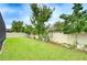 Spacious backyard featuring a lush green lawn, privacy fence, and mature trees offering ample shade at 13118 Payton St, Odessa, FL 33556