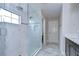 Modern bathroom featuring a glass shower, dark cabinets, marble countertops, and tile flooring at 13118 Payton St, Odessa, FL 33556
