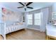 Bedroom featuring wood floors, ceiling fan and art featuring palm trees at 13118 Payton St, Odessa, FL 33556