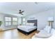 Bright, modern bedroom showcasing wood floors, multiple windows and stylish contemporary furniture at 13118 Payton St, Odessa, FL 33556