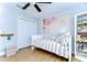 Charming bedroom with a ceiling fan, closet, and palm tree wall art, creating a relaxing and inviting space at 13118 Payton St, Odessa, FL 33556