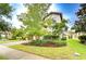 Charming home featuring a well-manicured lawn, mature trees, and a paved driveway, enhancing its curb appeal at 13118 Payton St, Odessa, FL 33556