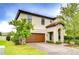 Attractive home with paver driveway and a two-car garage, enhanced by lush landscaping at 13118 Payton St, Odessa, FL 33556