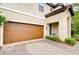 Close-up of the home's entrance, highlighting the wooden garage door and tiled driveway at 13118 Payton St, Odessa, FL 33556