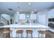 Kitchen showcasing a large center island with barstool seating, white cabinets, and modern pendant lights at 13118 Payton St, Odessa, FL 33556