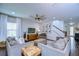 Bright living room with hardwood floors, ceiling fan, TV and staircase at 13118 Payton St, Odessa, FL 33556