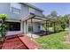 Backyard showcasing a covered patio with a vibrant red mulch pathway at 1402 Provincetown Cir, Lutz, FL 33549