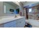 Bathroom featuring a white vanity, a large mirror, and a tiled shower-tub combo at 1402 Provincetown Cir, Lutz, FL 33549