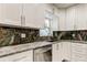 Kitchen with granite countertops, white cabinets and stainless steel appliances at 1402 Provincetown Cir, Lutz, FL 33549