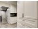 Pantry and utility area with built-in cabinets, granite countertops, and wood-look floors at 1402 Provincetown Cir, Lutz, FL 33549