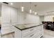 Modern kitchen island featuring a gorgeous countertop and white cabinets at 1402 Provincetown Cir, Lutz, FL 33549