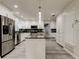 Modern kitchen featuring stainless steel appliances, a kitchen island, and sleek white cabinetry at 1402 Provincetown Cir, Lutz, FL 33549