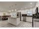 Modern kitchen featuring stainless steel appliances, a kitchen island, and sleek white cabinetry with a dining area at 1402 Provincetown Cir, Lutz, FL 33549