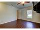 A spacious living room featuring dark wood flooring, a window, and a door at 1402 Provincetown Cir, Lutz, FL 33549