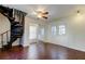 An empty living room featuring dark wood flooring, a spiral staircase, and lots of natural light at 1402 Provincetown Cir, Lutz, FL 33549