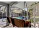 Covered porch featuring a wooden swing with access to a screened pool area at 1402 Provincetown Cir, Lutz, FL 33549