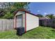 Backyard shed with a roll-up door and red trim, providing extra storage space at 1402 Provincetown Cir, Lutz, FL 33549