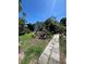 Exterior view of a yard with green grass, patio stones, lush trees, plants, and foliage at 1420 36Th N Ave, St Petersburg, FL 33704