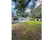 Spacious backyard featuring a lush green lawn, storage shed, and mature trees at 1507 W Le Compte Dr, Tampa, FL 33604