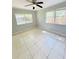 This bedroom has tile flooring, neutral walls, a ceiling fan, and windows that provide natural light at 1507 W Le Compte Dr, Tampa, FL 33604