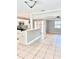 Open concept living room with tiled floors, a ceiling fan, and a view of the kitchen bar at 1507 W Le Compte Dr, Tampa, FL 33604