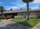 Cozy single-story home boasts a manicured lawn and lush greenery with a palm tree at 1508 16Th Se Cir, Largo, FL 33771