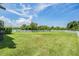 Sprawling backyard features a well-maintained lawn and a white picket fence under a bright blue sky with puffy clouds at 1634 Acadia Harbor Pl, Brandon, FL 33511