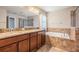 Bathroom featuring soaking tub, walk-in shower, and double vanity with granite counters at 1634 Acadia Harbor Pl, Brandon, FL 33511