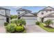 Charming two-story home featuring lush landscaping and a brick paver driveway at 1634 Acadia Harbor Pl, Brandon, FL 33511