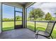 Screened patio with view of the backyard with a white picket fence and grassy area at 1634 Acadia Harbor Pl, Brandon, FL 33511