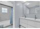 Modern bathroom features a double sink vanity and shower with blue patterned curtain at 1706 Belleair Forest Dr # 146, Belleair, FL 33756