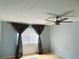Cozy bedroom with a ceiling fan, large window, and neutral-toned walls at 1706 Belleair Forest Dr # 146, Belleair, FL 33756