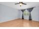 Bedroom featuring sleek ceiling fan, light hardwood floors and a window with gray curtains at 1706 Belleair Forest Dr # 146, Belleair, FL 33756