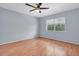 A bright bedroom featuring light wood floors, ceiling fan, and a sunny window at 1706 Belleair Forest Dr # 146, Belleair, FL 33756