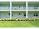 Three story building with light blue painted facade, railings and green grass at 1706 Belleair Forest Dr # 146, Belleair, FL 33756