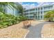 Lush courtyard with benches and stone pathways in a tropical setting at 1706 Belleair Forest Dr # 146, Belleair, FL 33756