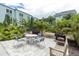 Grilling area and seating is nestled among tropical landscaping in the common courtyard at 1706 Belleair Forest Dr # 146, Belleair, FL 33756