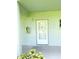 Close-up of an exterior door, painted white, and a small garden in front of the house at 1706 Belleair Forest Dr # 146, Belleair, FL 33756