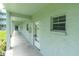 Hallway to unit with light blue painted exterior, concrete floor, and large window at 1706 Belleair Forest Dr # 146, Belleair, FL 33756