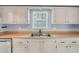 Galley style kitchen features a stainless steel sink with light wood colored countertops at 1706 Belleair Forest Dr # 146, Belleair, FL 33756
