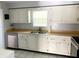 Classic kitchen featuring white cabinets, stainless steel appliances, and a double sink at 1706 Belleair Forest Dr # 146, Belleair, FL 33756