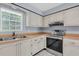Galley kitchen boasts ample cabinet space, stainless steel appliances, and bright countertops at 1706 Belleair Forest Dr # 146, Belleair, FL 33756
