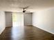 Spacious living room featuring ceiling fan, sliding glass door and modern laminate flooring at 1706 Belleair Forest Dr # 146, Belleair, FL 33756