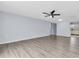 Living room featuring wood floors, a fan, and view to the kitchen at 1706 Belleair Forest Dr # 146, Belleair, FL 33756
