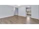 Living room featuring wood floors, view to the kitchen and white cabinets at 1706 Belleair Forest Dr # 146, Belleair, FL 33756