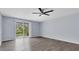 Spacious living room featuring wood floors, a fan, and sliding glass doors to the patio at 1706 Belleair Forest Dr # 146, Belleair, FL 33756